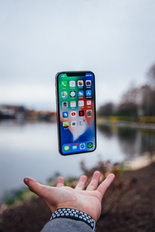 A salesman tossing a phone in the air outside before leaving a sales message