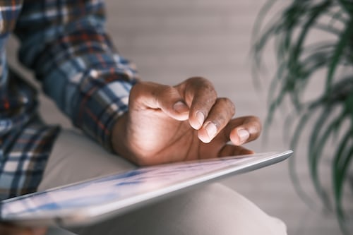 A person using a tablet to display a virtual sales meeting